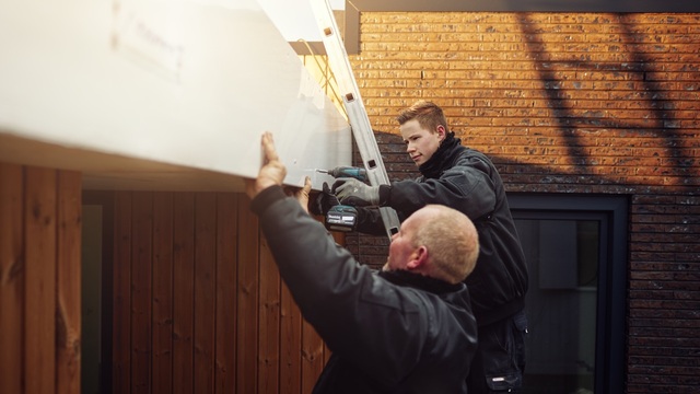 Twee mannen monteren een kunststof boeideel.